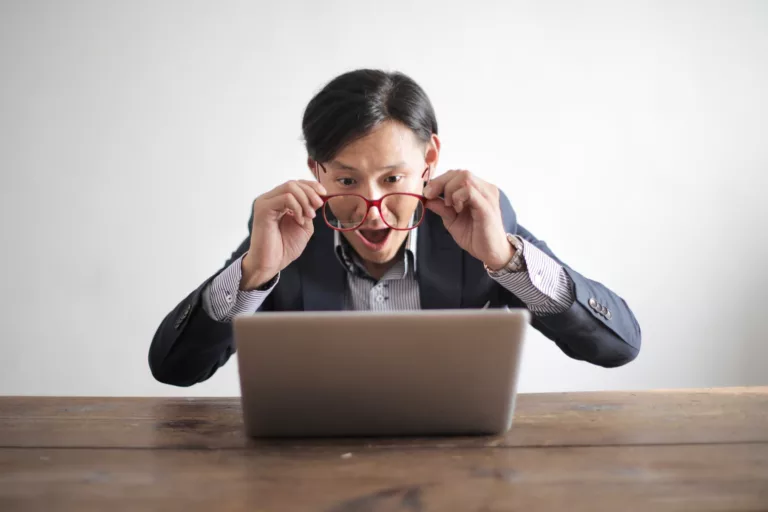 Amazed formal male looking at laptop screen